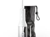 une brosse à dents électrique blanche à côté d'un sac noir