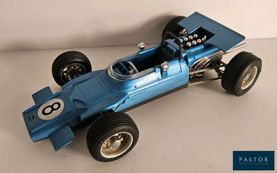 une maquette bleue d'une voiture de course posée sur une surface blanche