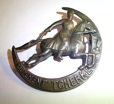a metal badge with a horse and rider on it