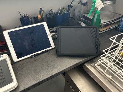deux ordinateurs portables et une tablette posés sur un comptoir