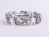 un gros plan d'un bracelet en argent orné de fleurs
