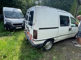 a man standing next to a white van in the grass