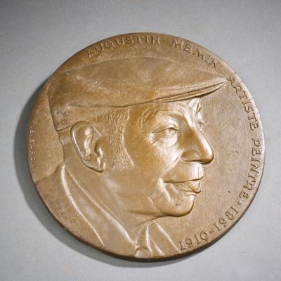 une médaille de bronze représentant un homme coiffé d'un chapeau