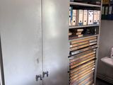 une armoire métallique comportant de nombreux tiroirs, dans une pièce