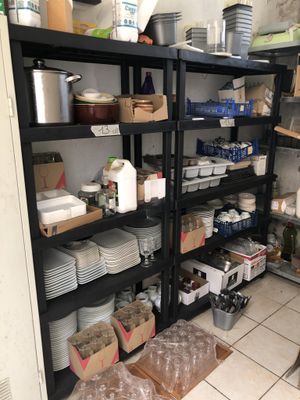 a room with a lot of dishes and pans on the shelves