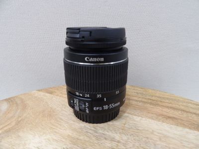 a camera lens on a wooden table with a white background