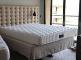 a bed with a mattress and a chair in a room