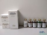 des flacons de liquide et une boîte de médicaments posés sur une table