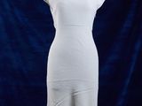 une robe blanche posée sur un mannequin, devant un fond bleu