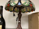 a lamp that is sitting on a shelf next to a bottle of wine