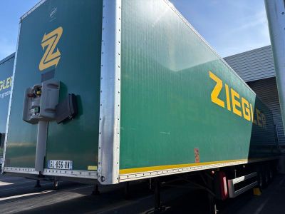un camion vert et jaune garé devant un immeuble