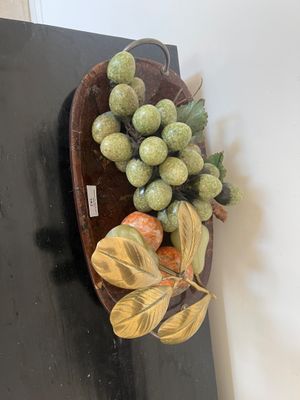 un bol de fruits posé sur une table sur laquelle se trouve une feuille