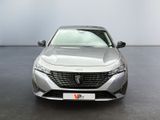 the front view of a silver car parked in a showroom
