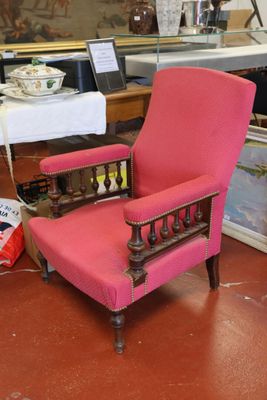 une chaise rose qui se trouve dans une pièce