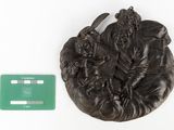 a statue of a man sitting on a leaf with a credit card next to it