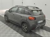 a grey car parked in a garage with a black and white checkered floor