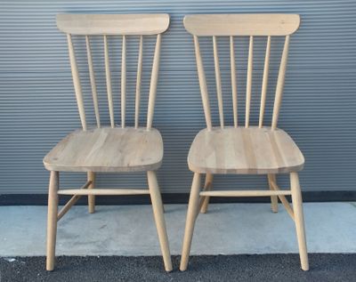 deux chaises en bois placées l'une à côté de l'autre devant un mur