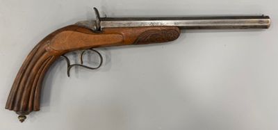 un vieux pistolet accroché au mur, muni d'une crosse en bois
