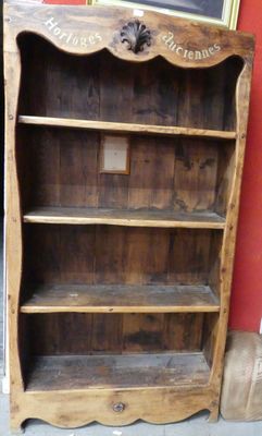 une bibliothèque en bois avec un tableau accroché au mur