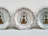 trois assiettes ornées de motifs décoratifs posées sur une surface blanche