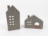 deux petites maisons en béton situées l'une à côté de l'autre sur une surface blanche