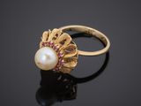 a gold ring with a pearl and ruby stones