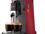 a close up of a coffee maker with two cups of coffee