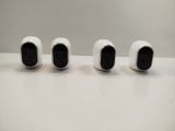 three white cameras sitting on top of a table next to each other