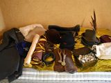 a bed that has a lot of hats and other items on it