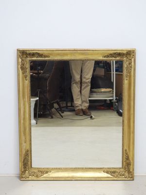 un homme debout devant un miroir dans une pièce