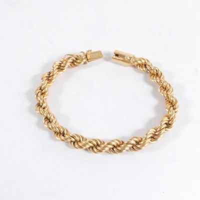 un bracelet en or tressé sur fond blanc