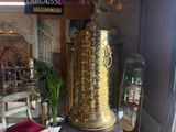 a gold vase sitting on top of a table in front of a mirror