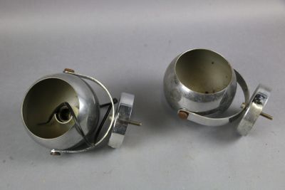 two silver metal objects sitting on a white surface