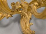 a close up of a gold leafed candle holder on a white surface