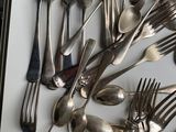 a lot of forks and spoons that are on the table