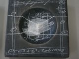 a black plate with a drawing on it on a table