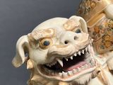 a figurine of a dog sitting next to a vase