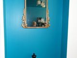 a blue wall with a mirror and a chess piece on it