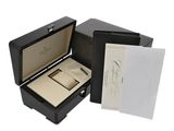 an open box with a watch inside of it on a white surface