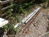 a broken piece of wood on the ground next to a fence