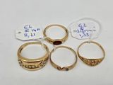 four gold rings with garnets and tags on them
