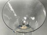 a clear glass bowl with a metal base on a table