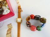 une montre, des bracelets et un coffret à bijoux posés sur une table