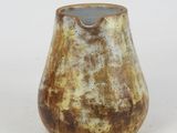 a brown and white vase sitting on a white surface