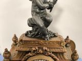 a clock with a statue of a boy on top of it