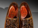pair of wooden shoes with carved flowers and leaves on them