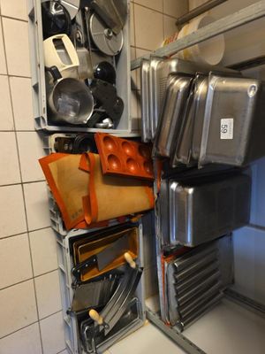 de nombreuses casseroles et poêles accrochées au mur de la cuisine