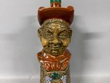a ceramic figurine of a man with a hat on his head