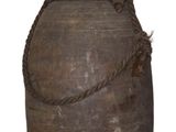 un grand vase marron entouré d'une corde
