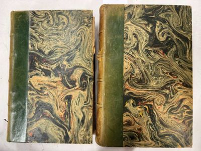 un vieux livre à la couverture verte posé sur une table blanche